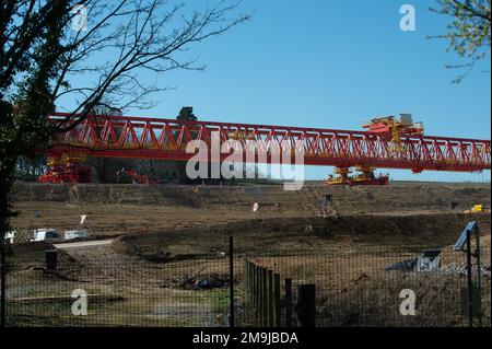 Denham, Großbritannien. 19. März 2022. HS2 Bauarbeiten für das Colne Valley Viadukt. Am ehemaligen Denham Water Ski Club neben der North Orbital Road in Denham werden Betonpiers aufgestellt. Die 700-Tonnen-Trägermaschine HS2 High Speed Rail mit dem Namen Dominique (abgebildet) ist jetzt in Betrieb und hat damit begonnen, einige der vorgegossenen Betonbrückensegmente auf das erste von 56 Pier-Segmenten für den HS2 High Speed 2 Colne Valley Viaduct zu bringen. Das Colne Valley Viaduct wird die längste Eisenbahnbrücke in Großbritannien sein. Kredit: Maureen McLean/Alamy Stockfoto