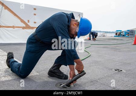 SASEBO, Japan (19. Mai 2022) Aviation Boatswain’s Mate (Handling) Airman Kevin Hunt aus Washington, D.C., der dem nach vorn entsandten Amphibienschiff USS America (LHA 6) zugeteilt wurde, sprüht Farbe von einer Gleitöse auf dem Cockpit des Schiffes ab. Amerika, das führende Schiff der America Amphibious Ready Group, ist im Zuständigkeitsbereich der US-amerikanischen 7.-Flotte tätig, um die Interoperabilität mit Verbündeten und Partnern zu verbessern und als bereitstehende Eingreiftruppe zur Verteidigung von Frieden und Stabilität in der Region Indo-Pazifik zu dienen. Stockfoto