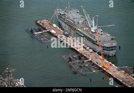 Luftaufnahme eines Abschnitts der Marinestation mit Zerstörer und U-Boot (D&S) Pier Nr. 21. Auf der Südseite des Piers befindet sich das U-Boot USS EMORY S. LAND (AS-39) mit vier nuklearbetriebenen Angriffs-U-Booten der Los Angeles-Klasse, die auf der Nordseite festgemacht sind, einschließlich der USS ATLANTA (SSN-712), der USS JACKSONVILLE (SSN-699) und des unbekannten U-Boots und der USS HAMPTON (SSN-767). Basis: Marine Air Station, Norfolk Bundesstaat: Virginia (VA) Land: Vereinigte Staaten von Amerika (USA) Stockfoto