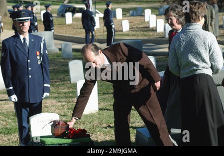 DIE EHRENMÄNNER DER US Air Force (USAF), DER SENIOR AIRMAN (SRA) Jeremiah Johnson, zollt dem ehemaligen Sekretär der Air Force (SECAF) John L. McLucas Tribut, indem er die Todeswache hält, während Familienmitglieder während seiner Beerdigung auf dem Nationalfriedhof von Arlington (ANC) Blumen an seiner letzten Ruhestätte platzieren. Basis: Arlington National Cemetery Bundesstaat: Virginia (VA) Land: Vereinigte Staaten von Amerika (USA) Stockfoto