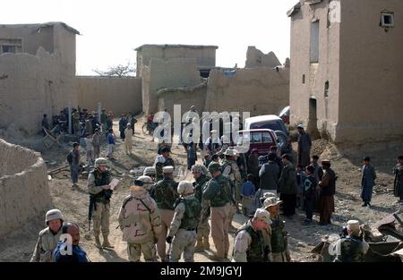 Im Dorf Bakhshi Kayal versammeln sich die Dorfbewohner um die der 455. Expeditionary Operations Group (EOG) zugeteilten US Air Force (USAF), die den Einheimischen Kleidung, Schuhe, Nahrungsmittel und Schulbedarf zur Unterstützung der Operation DAUERHAFTE FREIHEIT zur Verfügung stellen. Betrifft Operation/Serie: DAUERHAFTE FREIHEITSBASIS: Bakhshi Kayal Land: Afghanistan (AFG) Stockfoto