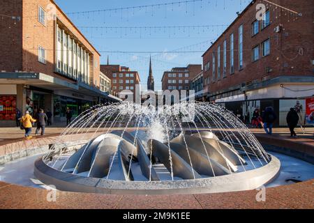 Der Springbrunnen im Smithford Way im Zentrum von Coventry zwischen dem oberen und unteren Bezirk. Die gesamte Anlage wurde für die Kulturstadt 2021 renoviert. Vom Brunnen aus blickt man auf das obere Viertel in Richtung des Turms der Heiligen Dreifaltigkeitskirche in der Ferne. Stockfoto