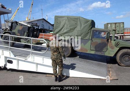 030201-M-7031A-010. [Complete] Bildunterschrift: Als das US Marine Corps (USMC) M1042 High-Mobility Multipurpose Wheeled Vehicle (HMMWV) mit einer Beleuchtungseinheit herauskommt, wird der Austal Westpac Express, ein australisches Hochgeschwindigkeitsfahrzeug (HSV), USMC Private First Class (PFC) N. Taylor, 3. Transport Support Battalion (TSB), Combat Service Support Detachment (CSSD), angeschlossen an 3. Bataillon (BN), 8. Marines (MAR), (3/8), zählt es zusammen mit anderen Fahrzeugen, die vom Schiff kommen. Marines aus dem 3/8. "Unit Deployment Program" von der Marine Corps Base (MCB) Camp Lejeune North Carolina (NC), bereite dich auf den Einsatz vor Stockfoto