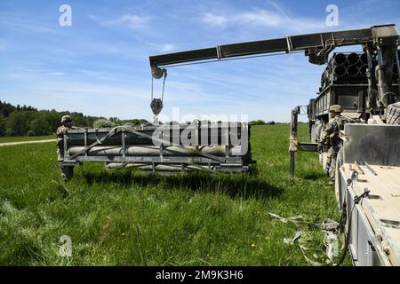 USA Soldaten, die der 41. Artilleriebrigade zugeteilt wurden, laden ein M270 Multiple Launch Rocket System herunter, um Wettbewerber vorzubereiten, die im Rahmen des Brigade Best by Test Wettbewerbs im Grafenwoehr-Trainingsbereich des 7. Armeeausbildungskommandos am 19. Mai 2022 auf Fahrzeuge geladen werden. Stockfoto