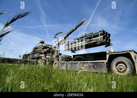 USA Soldaten, die der 41. Artilleriebrigade zugeteilt wurden, laden ein M270 Multiple Launch Rocket System herunter, um Wettbewerber vorzubereiten, die im Rahmen des Brigade Best by Test Wettbewerbs im Grafenwoehr-Trainingsbereich des 7. Armeeausbildungskommandos am 19. Mai 2022 auf Fahrzeuge geladen werden. Stockfoto