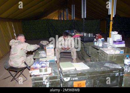 US Navy (USN) Hospital Corpsman, PETTY Officer Third Class (HM3) Jason Delon (Zentrum), zugewiesen zu 7. Marines 3/4 Headquarters/Support Company, hilft bei der Überprüfung der medizinischen Versorgung im Medical Zelt in Camp Coyote, Kuwait, während der Operation DAUERHAFTE FREIHEIT. Betreff Operation/Serie: DAUERHAFTE FREIHEITSBASIS: Camp Coyote Country: Kuwait (KWT) Stockfoto