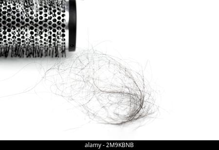 Haarverlustkonzept mit Haarbürste und Haaren drauf. Konzept von Haarausfall, Glatze und Haarpflege Stockfoto