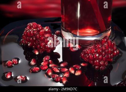 Saftige Granatapfelsamen im eigenen Saft. Nahaufnahme vor einem dunklen Hintergrund Stockfoto