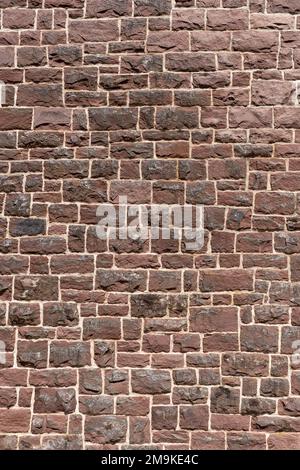 Alte Wand aus vielen roten Sandsteinen im Nahporträt-Format Stockfoto