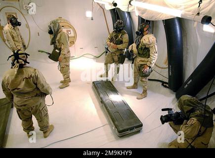 US Army (USA) Specialists (SPC) James Johnson (ganz rechts), Combat Documentation Production SPECIALIST, 55. Signal Company, verwendet eine digitale Videokamera, um die Sanitäter der US Navy (USN) und Marines des US Marines Corps (USMC) zu dokumentieren, die den 1. und 2. Force Services Support Groups (FSSG) zugewiesen sind. Während sie auf den Befehl Mission-Oriented Protective Haltungen (MOPP) Mast Only reagieren, während eines Trainingsabschnitts, der in einem Chemical Biological Protective Shelter (CBPS) in Camp Coyote, Kuwait, während der Operation DAUERHAFTE FREIHEIT durchgeführt wird. Das CBPS ist ein hochmobiles chemisch geschütztes Schutzsystem, das für entwickelt wurde Stockfoto