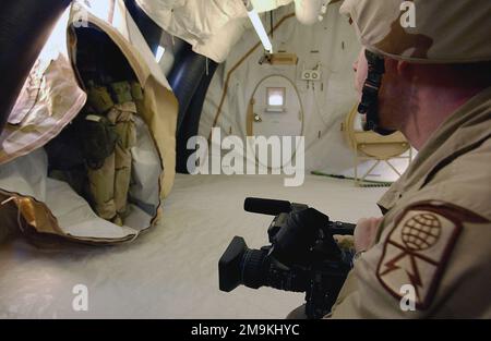 US Army (USA) Specialists (SPC) James Johnson (Vordergrund), Combat Documentation Production SPECIALIST, 55. Signal Company, verwendet seine digitale Videokamera, um die Mitarbeiter der US Army (USA) und des US Marine Corps (USMC) zu dokumentieren, während sie zusammen an der Montage eines Chemical Biological Protective Shelter (CBPS) in Camp Coyote, Kuwait, Während des Betriebs DAUERHAFTE FREIHEIT. Die CBPS ist ein hochmobiles chemisch geschütztes Schutzsystem für den medizinischen Notfalleinsatz in vorderen Schlachtgebieten. Betreff Operation/Serie: DAUERHAFTE FREIHEITSBASIS: Camp Coyote Country: Kuwait (KWT) Stockfoto
