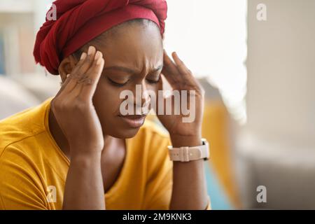 afroamerikanische Frau mit Kopfschmerzen zu Hause Stockfoto