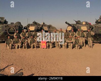 US Marine Corps (USMC) Marine STAFF Non-Commissioned Officers (NCO) und Officers of Echo Company (CO), 2. Battalion (BN), 5. Marines (MAR) (2/5), Marine Corps Base (MCB) Camp Pendleton, California (CA), posieren für ein Foto, bevor sie die irakische Grenze während der Operation DAUERHAFTE FREIHEIT überqueren. Hinter ihnen befinden sich die M1A2 Abrams Main Battle Tanks (MBT) und die AAV7A1 Amphibious Assault Vehicles (AAV). (Unterdurchschnittliches Bild). Land: Kuwait (KWT) Stockfoto