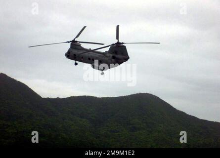 Ein US Marine Corps (USMC) CH-46 Sea Knight Helicopter, der dem Marine Medium Helicopter Squadron Two Six Five (HMM-265) zugeteilt wurde, fliegt während einer simulierten Truppeneinführungsübung in Camp Butler, Okinawa, Japan, über eine grüne Bergregion. (Unterdurchschnittliches Bild). Staat: Okinawa Land: Japan (JPN) Stockfoto