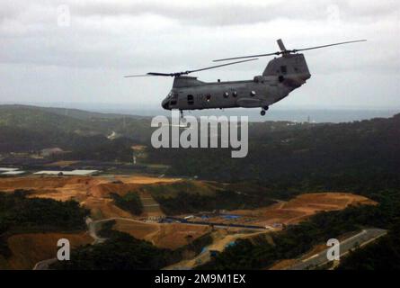 Ein US Marine Corps (USMC) CH-46 Sea Knight Helicopter, der dem Marine Medium Helicopter Squadron Two Six Five (HMM-265) zugeteilt wurde, fliegt während einer simulierten Truppeneinführungsübung in Camp Butler, Okinawa, Japan, über eine grüne Bergregion. (Unterdurchschnittliches Bild). Staat: Okinawa Land: Japan (JPN) Stockfoto