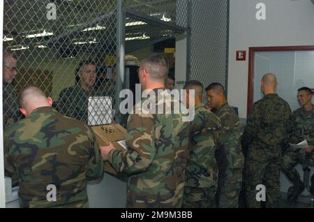 Personal des US Marine Corps (USMC) der Charlie Company, 4. Aufklärungsbataillon der Light Armored Reconnaissance (LAR), 4. Marine Division, Aufstellung an einem Lieferfenster, um ihre persönliche Ausrüstung zu holen. Basis: Camp Williams Bundesstaat: Utah (UT) Land: Vereinigte Staaten von Amerika (USA) Stockfoto