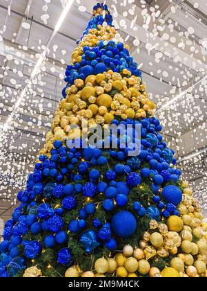 Ein großer Weihnachtsbaum mit gelben und blauen Kugeln. Stockfoto