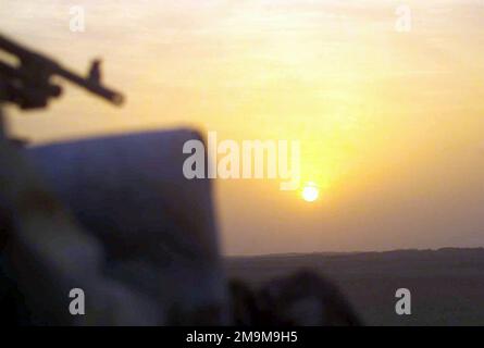 Ein Blick auf den Sonnenuntergang über der Kuwaitischen Wüste, von einem leichten gepanzerten Fahrzeug (LAV-25) des US Marine Corps (USMC) aus gesehen, das dem 1. Leichten gepanzerten Aufklärungsbataillon (LARB), 1. Marine Division, zugeteilt wurde und während der Operation DAUERHAFTE FREIHEIT patrouilliert. (Unterdurchschnittliches Bild). Land: Kuwait (KWT) Stockfoto