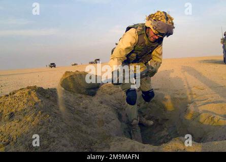 Ein Marine des US Marine Corps (USMC) von der Headquarters Company (HC), Regimental Combat Team-1 (RCT-1), gräbt eine Kampfposition im Verbreitungsgebiet, bevor die Einheit in den Irak überquert, um die Operation IRAQI FREEDOM vorzubereiten. Land: Kuwait (KWT) Stockfoto