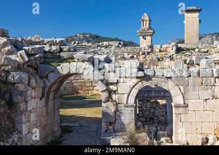 Eingangstor zum Theater der antiken Stadt Xanthos - Teil der Lykischen Art. Grabdenkmal von König Kybernis (Harfengrab), Säulengrab im Hintergrund. Stockfoto