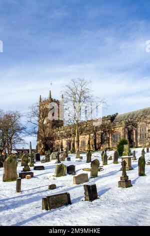 Der schneebedeckte Kirchhof und Grabsteine in der Pfarrei St. Mary kirche Sandbach Cheshire England im Winter Stockfoto