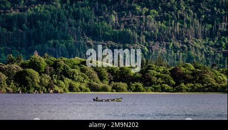 Ein einsamer Fischer, der in einem Lough Leane von einem Boot im Killarney National Park, Ring of Kerry, in der Nähe der Stadt Killarney, County Kerry, Irland angeln will Stockfoto