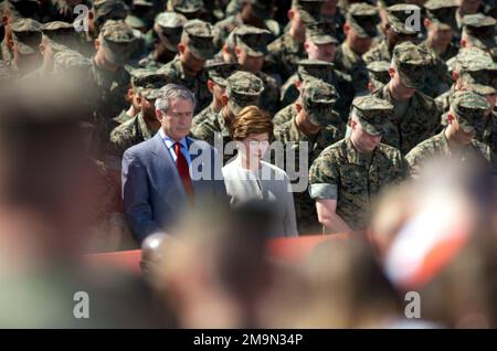Der US-Präsident George W. Bush und die First Lady Laura Bush sind umgeben von einer Galerie von Mitarbeitern des US-Marine Corps und verneigen sich bei ihrem jüngsten Besuch auf der Marine Corps Base (MCB) in Camp Lejeune, North Carolina, in einem Gebet vor ihren Köpfen. Basis: Marinestützpunkt, Camp Lejeune Bundesstaat: North Carolina (NC) Land: Szene der Vereinigten Staaten von Amerika (USA) Hauptkommando gezeigt: OBERBEFEHLSHABER Stockfoto