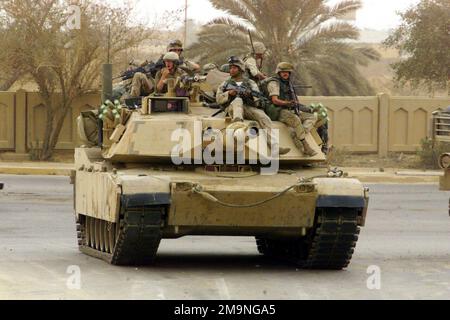 Mitarbeiter des US Marine Corps (USMC) des 3. Bataillons, 7. Marines nehmen während der Operation IRAQI FREEDOM eine Fahrt auf einem USMC M1A1 Abrams Main Battle Tank (MBT) auf den Straßen von Bagdad, Irak, auf. Operation/Serie: IRAKISCHE FREIHEITSBASIS: Bagdad Land: Irak (IRQ) Stockfoto