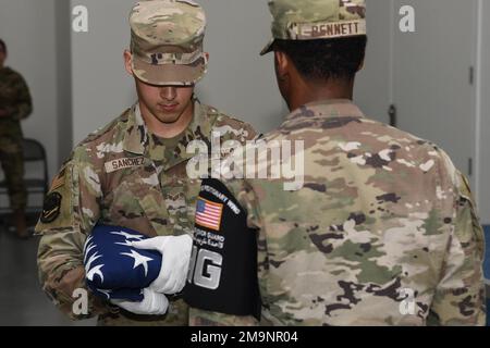 Mitglieder der 380. Air Expeditionary Wing's Honor Guard veranstalten im Rahmen einer offiziellen Zeremonie der National Police Week am 20. Mai 2022 auf dem Luftwaffenstützpunkt Al Dhafra, Vereinigte Arabische Emirate, eine Fahnenfahndung. Das zeremonielle Falten und die Präsentation der amerikanischen Flagge ist eine Hommage von dauerhafter Bedeutung für die Mitglieder des Militärs und ihre Familien im gesamten Verteidigungsministerium. Stockfoto