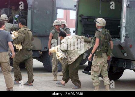 US Army (USA) Specialists (SPC) Edgar Hernandez und USA SPC Joseph Hudson, die beide dem 507. Wartungsbataillon zugewiesen sind, verlassen einen M997A2 Krankenwagen am Logistikstützpunkt Chesty, 65 Meilen südlich von Bagdad, Irak. SPC Hernandez und Hudson sind zwei von sieben amerikanischen Kriegsgefangenen, die während der Operation IRAKISCHE FREIHEIT sicher vom US Marine Corps (USMC) 3. Aufklärungszug mit leichter Panzerung, 1. Marine Expeditionstruppe wiedergefunden wurden. Betreff Operation/Serie: IRAKISCHE FREIHEITSBASIS: Logistisches Unterstützungsgebiet Chesty Country: Irak (IRQ) Stockfoto