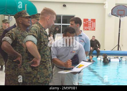 General (GEN) Michael W. Hagee (Mitte links), Befehlshaber des Marine Corps (CMC) und Sergeant Major des Marine Corps Alford McMichael (links), besuchen Sie ein Modul Amphibious Egress Trainer (MAET) in Camp Hansen, Okinawa, Japan. Herr Armando Alonzo (Mitte rechts), Site Manager für Survival Systems USA, und Herr Tom Lazzaro (hinten rechts) Director of Operations für Survival Systems USA, erläutern dem CMC die am Pool durchgeführten Vorgänge. GENERAL Hagee besuchte die III Marine Expeditionary Force (MEF) zum ersten Mal als CMC. Während seines Besuchs besichtigt er die Marinestützpunkte auf Okinawa, Stockfoto