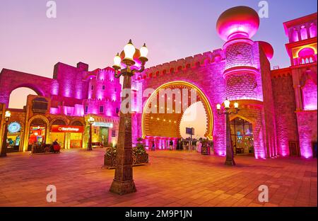 DUBAI, Vereinigte Arabische Emirate - 6. MÄRZ 2020: Der Kulturplatz des Global Village Dubai mit Blick auf das beleuchtete Kulturtor, dekoriert mit Hufeisenbogen und Windka Stockfoto
