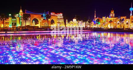 DUBAI, Vereinigte Arabische Emirate - 6. MÄRZ 2020: Panoramablick auf Global Village Dubai mit hellen beleuchteten Pavillons verschiedener Länder und LED-Unterwasserschirm im Pon Stockfoto