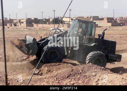 Ein Marine des US Marine Corps (USMC), der der 24. Service Support Group (SSG), der 24. Marine Expeditionary Unit (MEU), zugeordnet ist; Special Operations Capable (SOC) verwendet eine Tractor Rubber-tired Articulated Steering Multipurpose (TRAM), um Berms abzureißen, die Straßen blockieren, und um während der Operation IRAQI FREEDOM Kämpferpositionen entlang einer Hauptstraße in Al Rifa, Irak, zu entfernen. Operation/Serie: IRAKISCHE FREIHEITSBASIS: Al-Rifa-Land: Irak (IRQ) Stockfoto