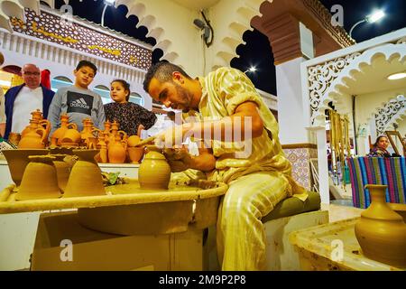 DUBAI, Vereinigte Arabische Emirate - 6. MÄRZ 2020: Der Töpfer macht den Tontopf am Töpferrad im marokkanischen Pavillon des Global Village Dubai, am 6. März in Dubai Stockfoto