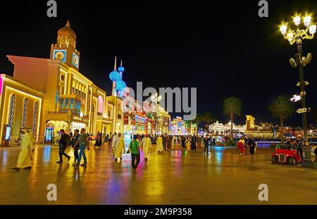DUBAI, Vereinigte Arabische Emirate - 6. MÄRZ 2020: Beleuchtete Pavillons des Global Village Dubai mit Uhrturm, Toren und Nachbildung der Kuwait Towers, am 6. März in Dubai Stockfoto