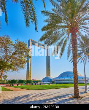 DUBAI, Vereinigte Arabische Emirate - 6. MÄRZ 2020: Üppige Palmen des Zabeel Park mit Kuppeln des Stargate Edutainment Park und Dubai Frame im Hintergrund, am 6. März in Dubai Stockfoto