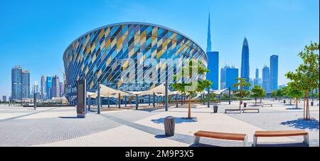 DUBAI, Vereinigte Arabische Emirate - 6. MÄRZ 2020: Panoramablick auf einen kleinen Park vor der Coca-Cola Arena und futuristische Wolkenkratzer aus Glas im Hintergrund, am 6. März in Dubai Stockfoto