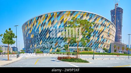 DUBAI, Vereinigte Arabische Emirate - 6. MÄRZ 2020: Panoramablick auf moderne Coca-Cola-Arena aus Glas mit topischen Büschen, grünen Pflanzen und Akazien im Vordergrund, am 6. März Stockfoto