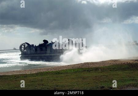 Ein Landungsschiff der US Navy (USN) mit Luftpolsterung (LCAC) verlässt den Strand am Inner Apra Harbor, Guam, und kehrt zu seinem Hilfsschiff zurück. Die LCAC nimmt hier an der Übung TANDEM-SCHUB 2003 Teil. Basis: US-Marinestreitkräfte, Marianen Staat: Guam (GU) Land: Nördliche Marianen (MNP) Stockfoto