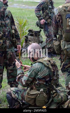 SOLDATEN DER US-Armee (USA) des 2. Bataillons, 27. Infanterie-Regiment (2/27) Charlie Company, 25. Infanterie-Division (ID) [Light], Schofield Barracks, Hawaii (HI), tarnen sich, bevor sie während des TANDEM-SCHUBS auf einer Insel als Teil einer Airborne Insert ausgewählt werden 2003. Basis: Polaris Point Marinestützpunkt Guam Bundesstaat: Guam (GU) Land: Nördliche Marianen (MNP) Stockfoto