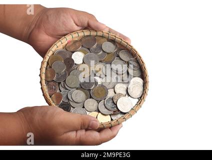 Münzen in einem Bambuskorb auf weißem Hintergrund. Sparkonzept Stockfoto