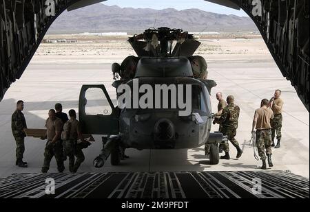 US Air Force (USAF) Airmen, die dem 66. Aircraft Maintenance Squadron (AMS) zugewiesen sind, laden einen USAF HH-60G Pave Hawk Helikopter in ein Flugzeug des Typs USAF C-17A Globemaster III auf dem Luftwaffenstützpunkt Nellis (AFB), Nevada, in Vorbereitung auf einen bevorstehenden Einsatz hoch. Basis: Luftwaffenstützpunkt Nellis Bundesstaat: Nevada (NV) Land: Vereinigte Staaten von Amerika (USA) Stockfoto