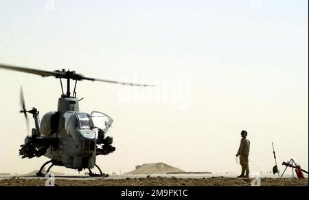 US Marine Corps (USMC) Lance Corporal (LCPL) John Ideus, Marine Wing Support Squadron Three Seven One (MWSS-371) wartet während der Operation IRAQI FREEDOM auf den Einsatz des Aah-1W Super Cobra Helikopters an einem vorderen Tankpunkt (FARP) am Luftwaffenstützpunkt Tallil, Irak. Operation/Serie: IRAKISCHE FREIHEITSBASIS: Luftwaffenstützpunkt Tallil Staat: DHI Qar Land: Irak (IRQ) Stockfoto