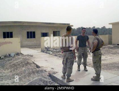 US Navy (USN) SeaBees, die dem Marinebataillon One 33 (NMBC-133) zugeteilt wurden, evaluieren während der Operation IRAQI FREEDOM ein Wiederaufbauprojekt, das derzeit auf dem ehemaligen Militärgelände in einem Dorf in der irakischen Region Najaf läuft. Das Gelände wird gerade als Schuleinrichtung umgebaut. (Unterdurchschnittliches Bild). Operation/Serie: IRAKISCHE FREIHEITSBASIS: Land Najaf: Irak (IRQ) Stockfoto