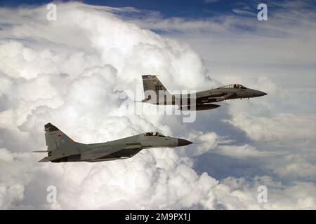 Ein russischer MiG-29-Jäger, geflogen vom deutschen Luftwaffer-Piloten Oberst (LCOL) Tom Hahn, Geschwader-Kommandant (SC) des deutschen (DEV) 73. Fighter Wing (FW) oder „Steinhoff“, bleibt in Formation mit einer US Air Force (USAF) F-15C Eagle, gesteuert von Major (MAJ) Greg Thomas, Test Squadron (TS 28.) Nellis Air Force Base (AFB), Nevada, über dem Bundesstaat Florida während einer gemeinsamen Trainingsübung. Bundesstaat: Florida (FL) Land: Vereinigte Staaten von Amerika (USA) Stockfoto