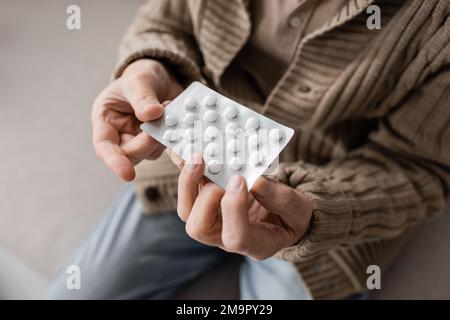 Partielle Sicht auf den alten Mann mit Parkinsonsyndrom-Pillen-Halten in zitternden Händen, Stockbild Stockfoto