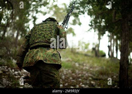 Ein Soldat der Japan Ground Self-Defense Force (JGSDF) geht während einer simulierten Kampfverteidigung während der Übung Southern Jackaroo 22 im Shoalwater Bay Training Area, Queensland, Australien, am 21. Mai 2022 in seine Position. Southern Jackaroo ist eine multilaterale Übung, die von Marines mit Marine Rotational Force-Darwin, der australischen Armee und JGSDF-Soldaten durchgeführt wird und sich auf die Ausbildung von Feuerwaffen und kombinierten Waffen konzentriert. Stockfoto