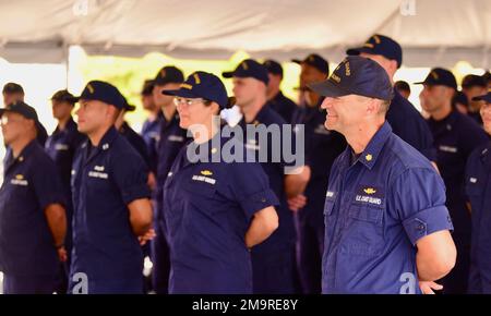 Die Crew des Coast Guard Cutter Munro genießt während der Zeremonie zum Befehlswechsel in Santa Rita, Guam, am 19. Mai 2022 Geschichten aus den letzten zwei Jahren. Die Zeremonie findet vor der versammelten Crew statt und bestätigt den Männern und Frauen der Einheit, dass die Autorität des Kommandos aufrechterhalten wird. Stockfoto