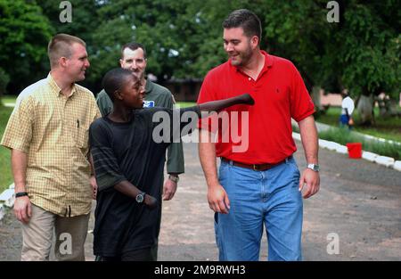 030820-F-6701P-009. [Complete] Szene Caption: Abraham Bangura, ein 15-jähriger Überlebender eines Rebellenangriffs während der Bürgerkriege in Sierra Leone, spricht mit dem US Air Force (USAF) Special Agent (SA) Vance Little (links) und SA George Breed, beide dem Air Force Office of Special Investigations (AFOSI) zugeteilt, Wurde mit der 398. Air Expeditionary Group (AGE) in Lungi Sierra Leone während der Joint Task Force Liberia (JTF Liberia) eingesetzt. Abraham beobachtete, wie Rebellen seinen Vater in seinem kleinen Dorf Kono töteten, wickelten seine Hände dann in Plastiktüten, tauchten sie mit Benzin ein und setzten sie in Angst in Brand Stockfoto